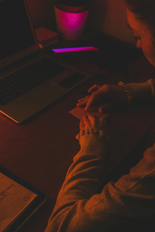 a woman is at a table typing on a laptop