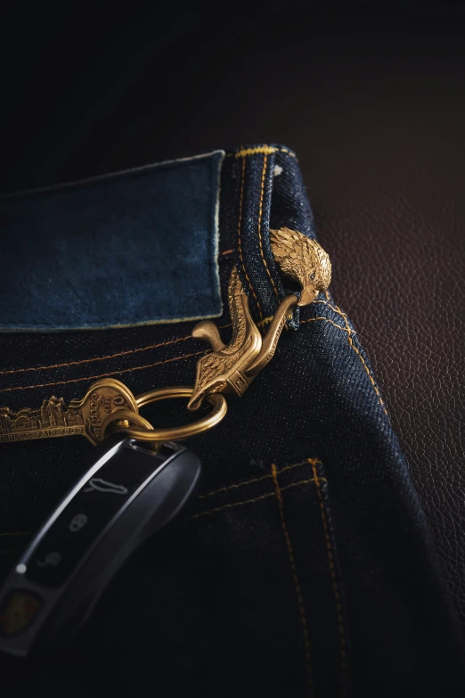 a metal bird charm is seen in a jeans pocket