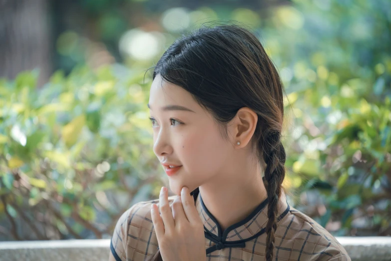 young female student wearing traditional chinese dress standing in the sun