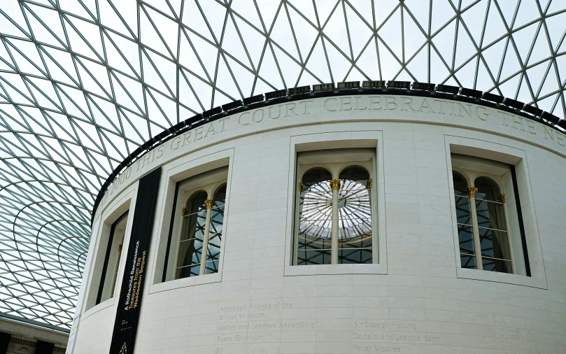 there is a modern glass roof structure behind the building