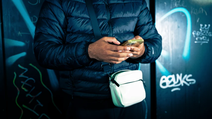 a woman in a blue coat texting on her phone