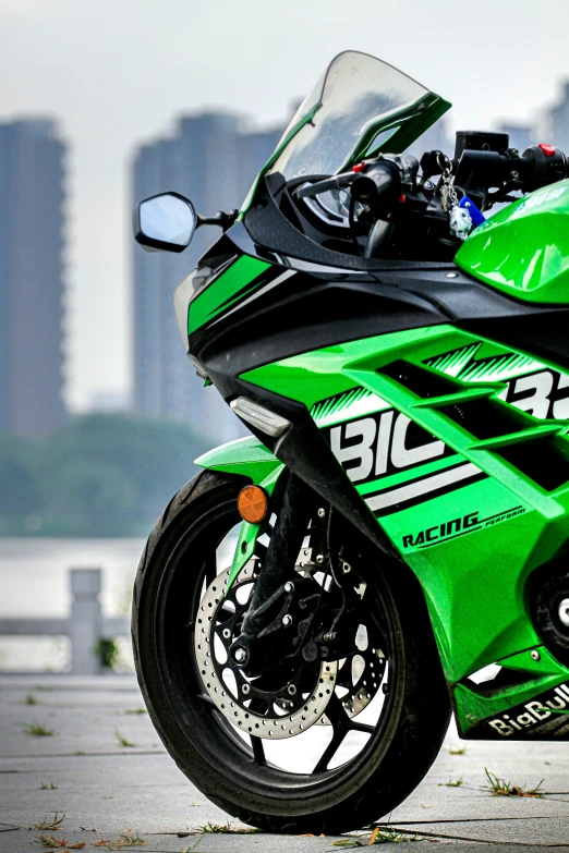 a bright green motorcycle sits in front of the water