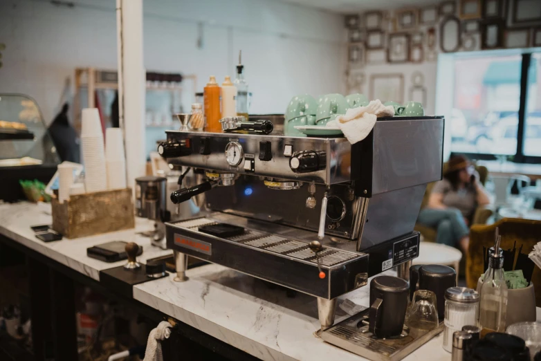 coffee machine sitting on top of a counter in front of some people