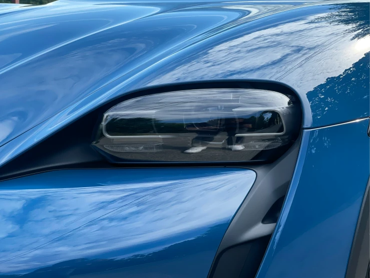 a blue sports car has its side mirror opened