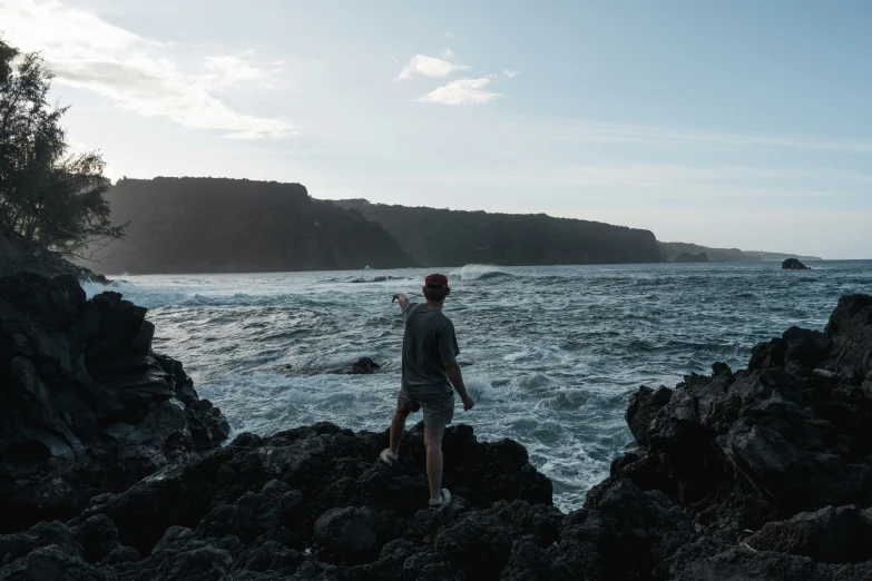 a person standing on rocks near the ocean