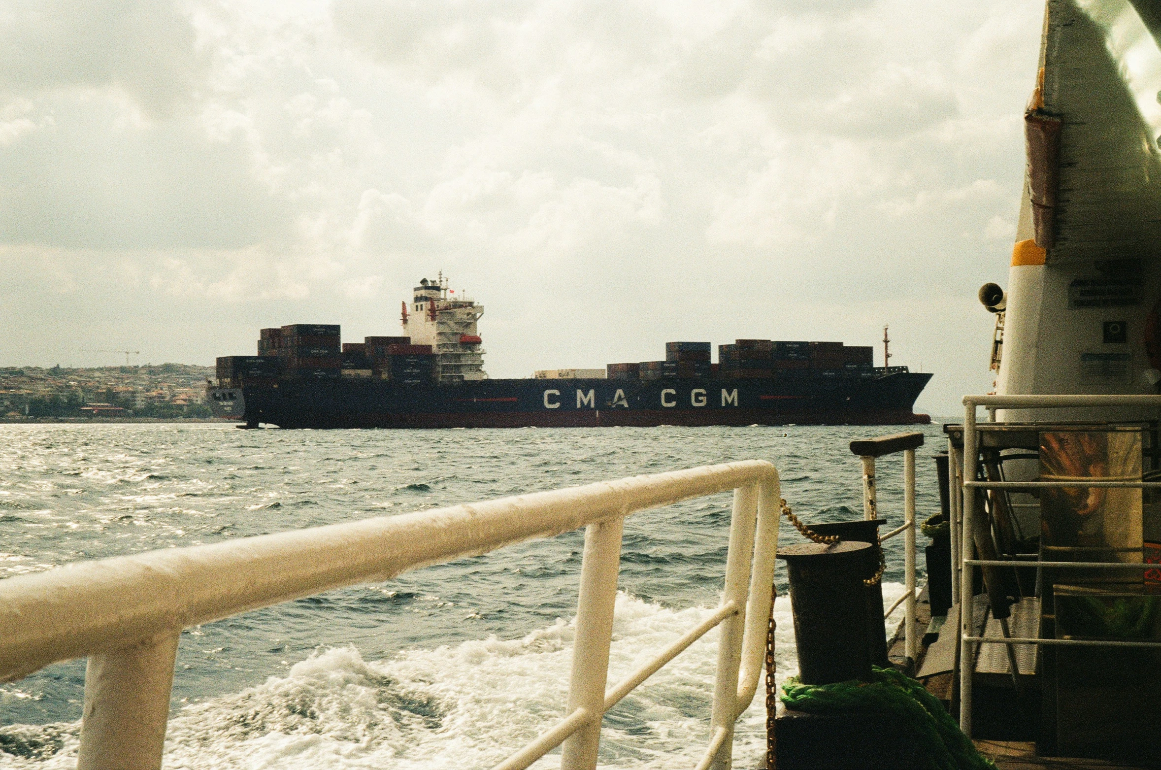 a cargo ship approaching the dock while another ship passes