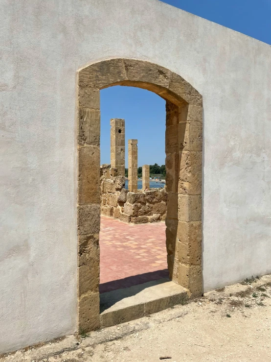 a stone arch with a red floor and no fence