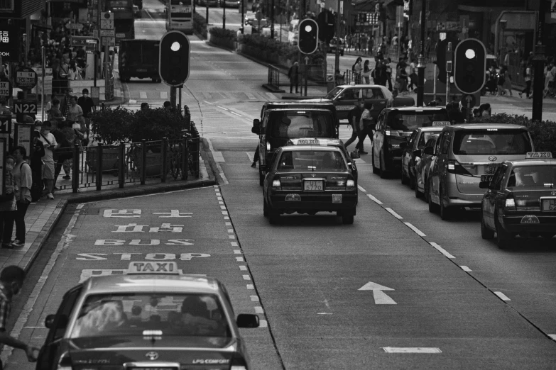 cars travelling down a busy city street next to a traffic light