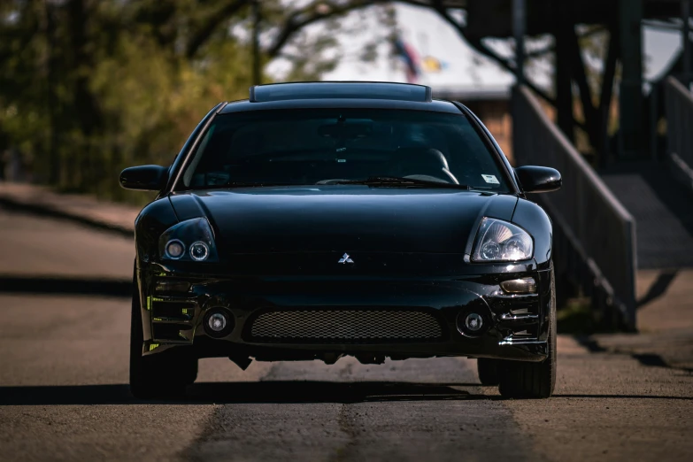 a dark colored sports car on the road