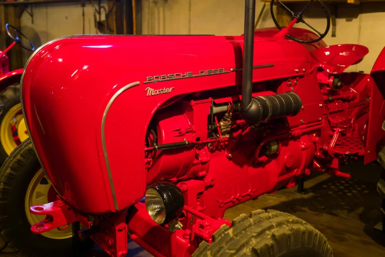 an old farm tractor, parked inside a shed