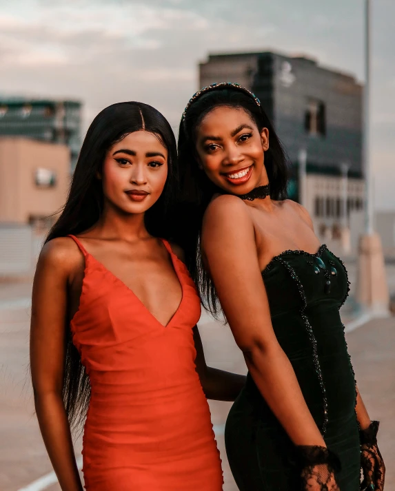 two girls standing together and wearing the same dress