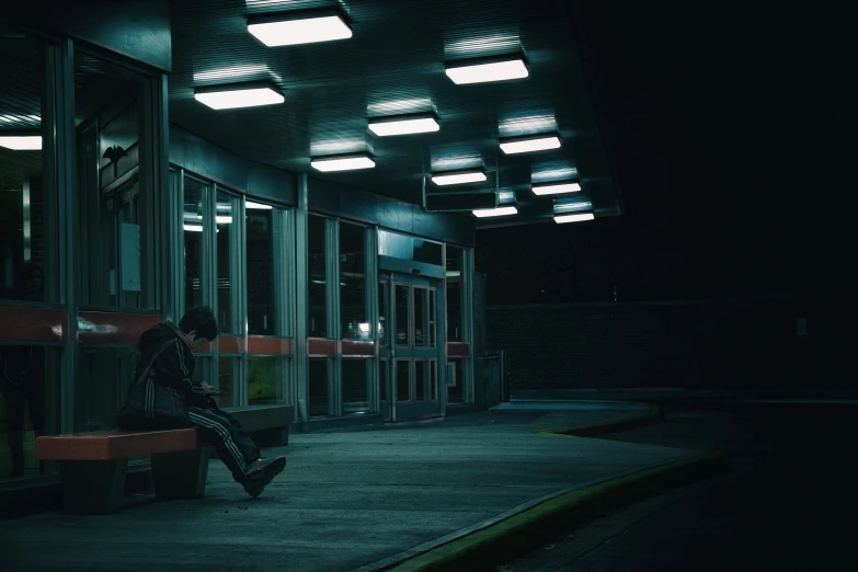 the man sits alone on the bench at night