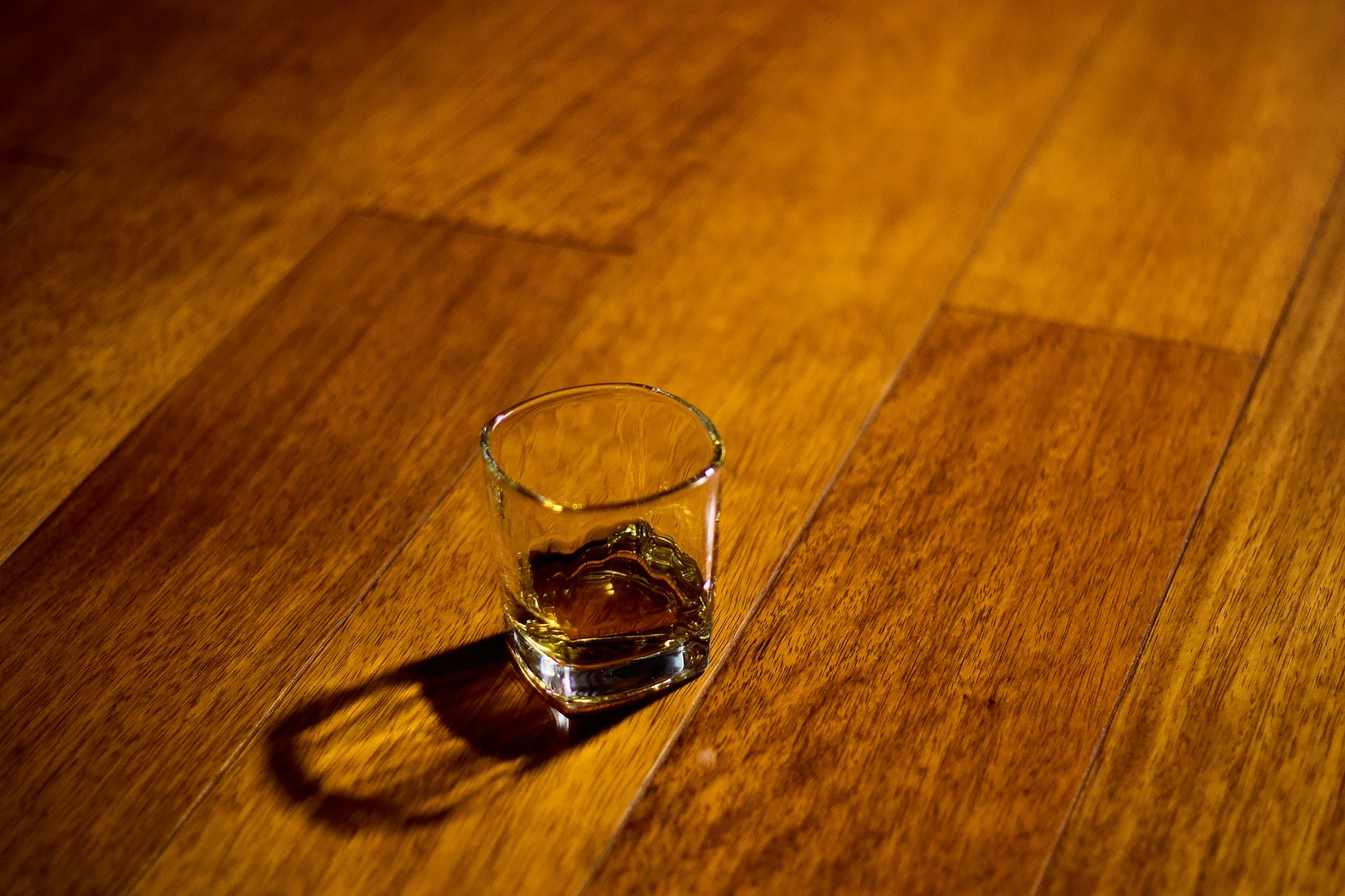 a glass sitting on top of a wooden floor