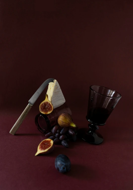 fruit and knife still on a red surface