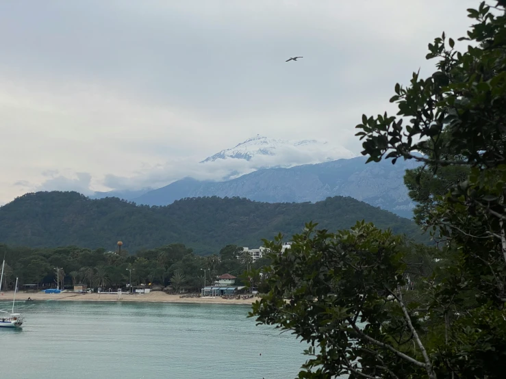 a small boat floating on the ocean in front of mountains