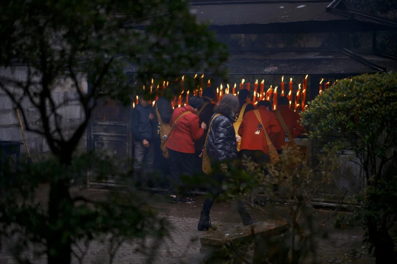 several people standing around with lit candles in the air