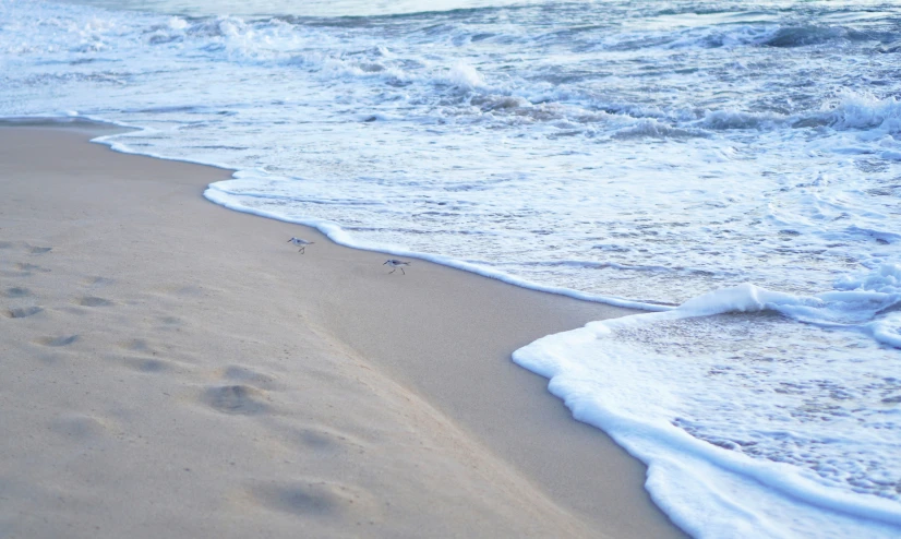 a sandy beach with waves lapping on it