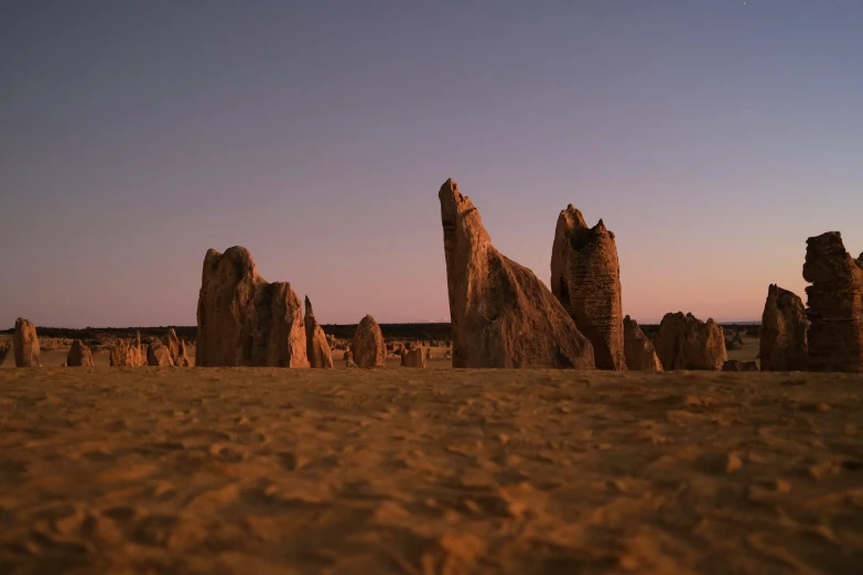 a group of rocks on top of a sandy beach