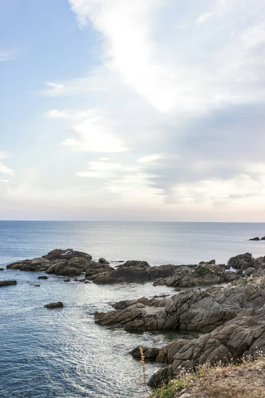 a person standing on rocks in the ocean