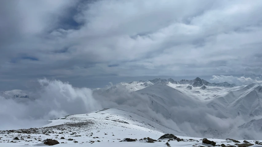 snow on the ground in front of a mountain range