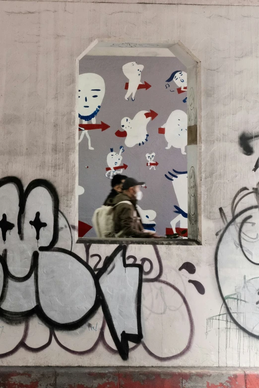 a man looking through a window at graffiti on the walls