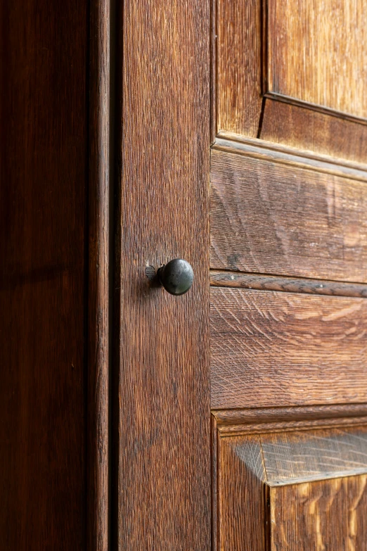 closeup of a wood door and handle, with the dark staining and grain on it