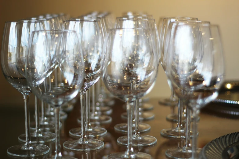 a line of many empty wine glasses sitting next to each other