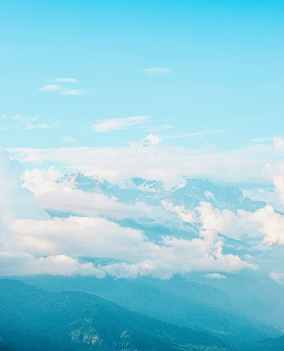 airplane in sky with clouds and mountain range