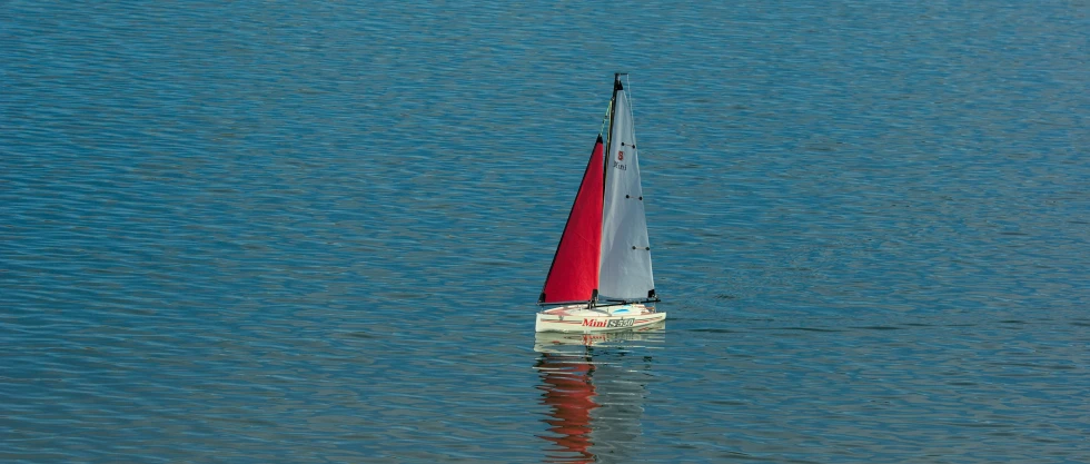 a sail boat is in the middle of a body of water