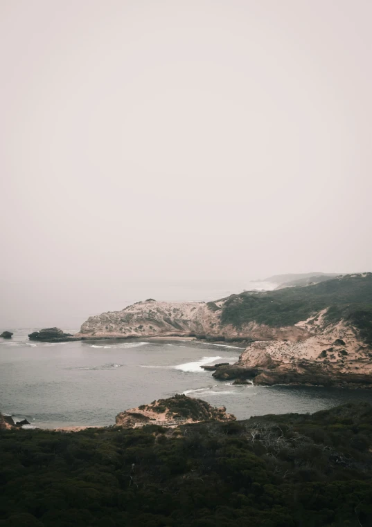 the water is calm and peaceful under a gray sky