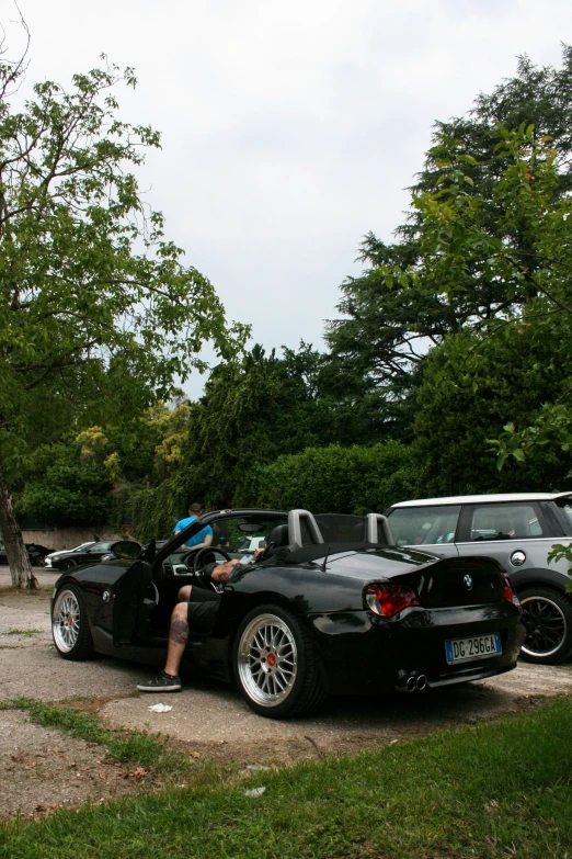 two cars that are parked side by side with people looking at them