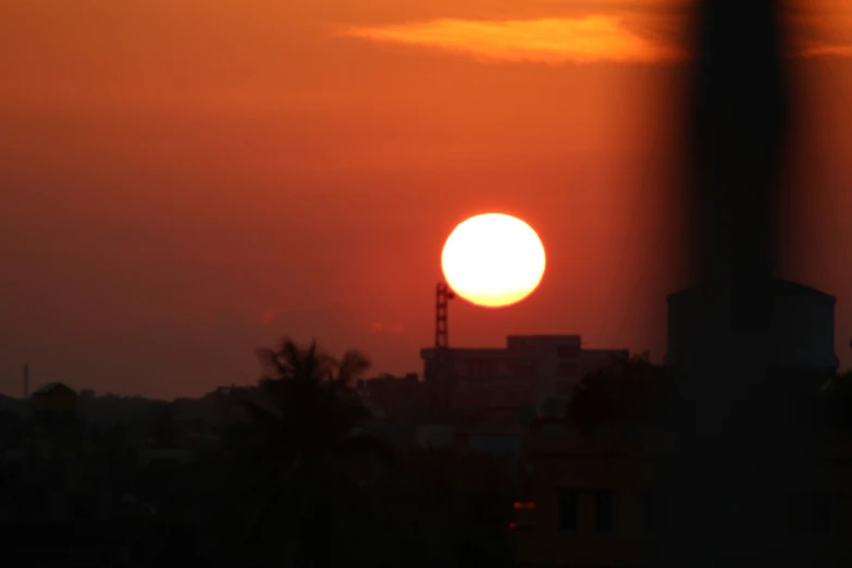 the sun is seen through clouds over a city