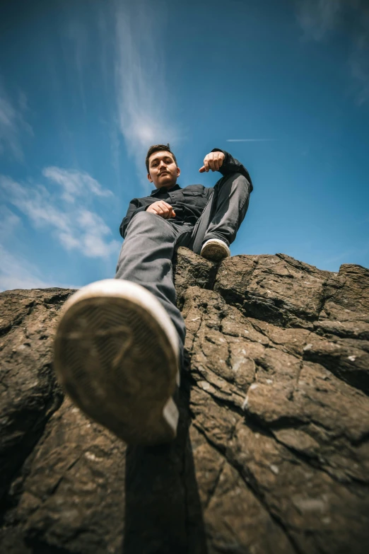 a man is sitting on a rock climbing