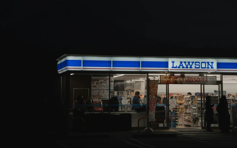 a store with blue and white stripes is lit up at night