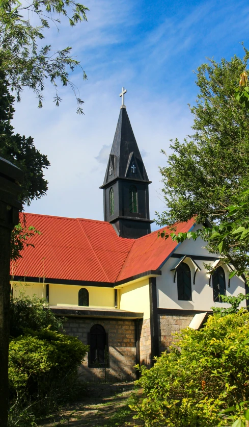 a large white building with red roof and a cross on top