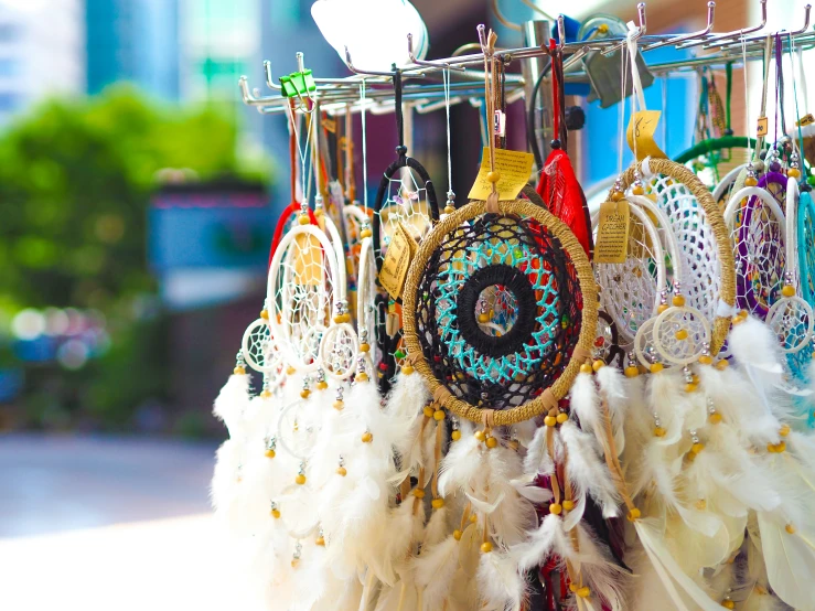 many different colors of feathers and mirrors hang on a rack