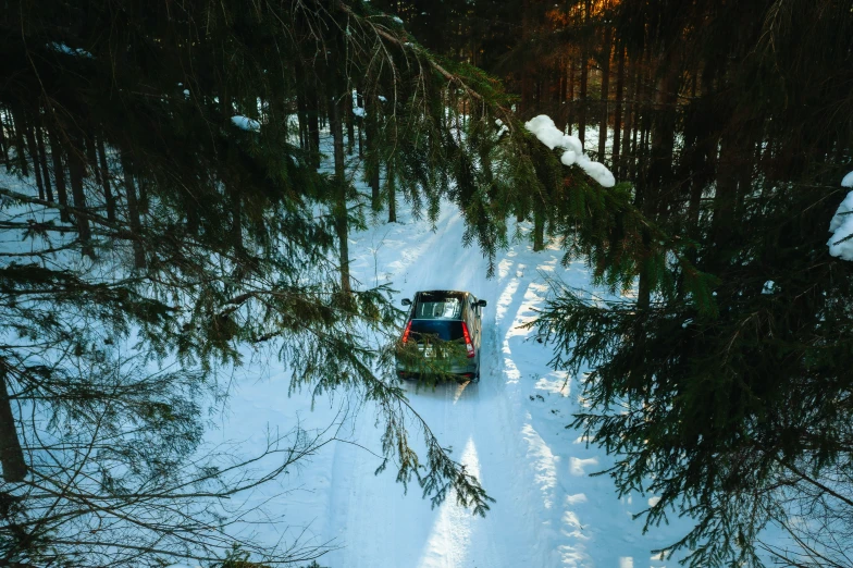 an over head view of a snow covered vehicle driving along a snowy path