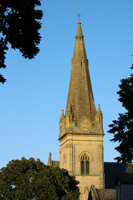 a church steeple is shown in the afternoon sun