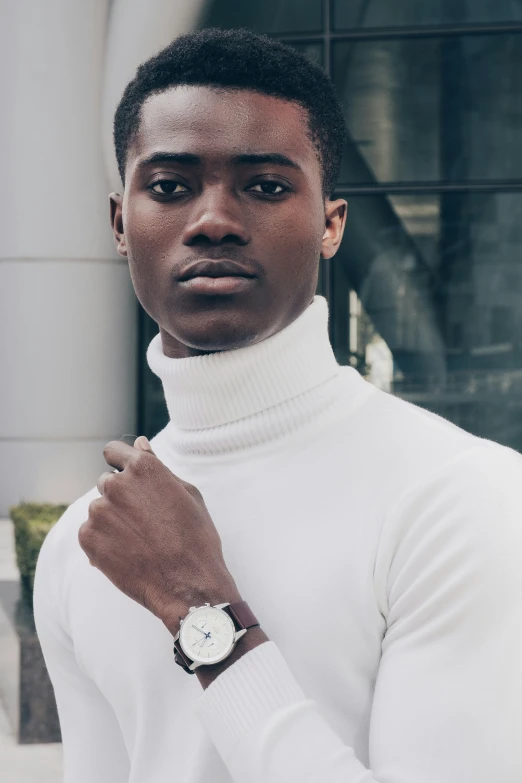 a man posing wearing a watch while wearing white