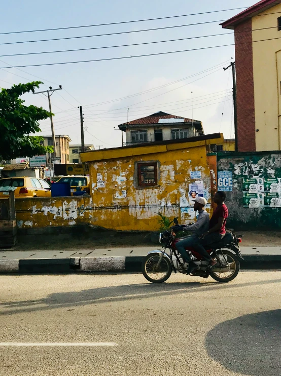 two people riding motorcycles down a city street