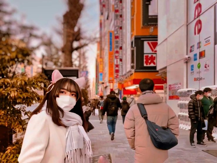 a woman walking down a street wearing a face mask