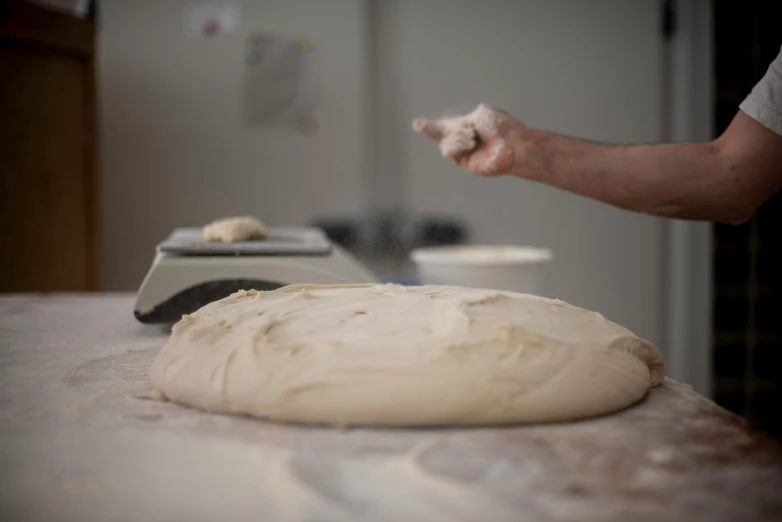 person about to throw a ball of food into an unbaked tortilla