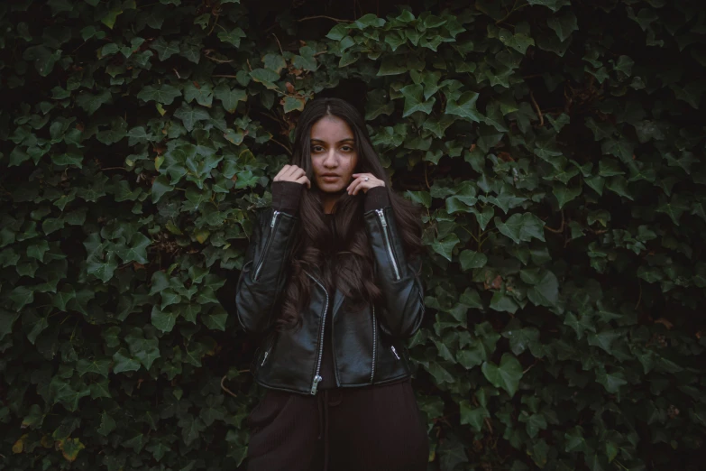 a girl posing for a po with a leafy background