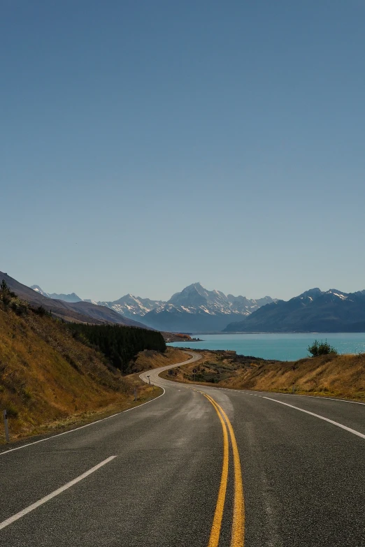 a long road goes through an expansive mountainous landscape