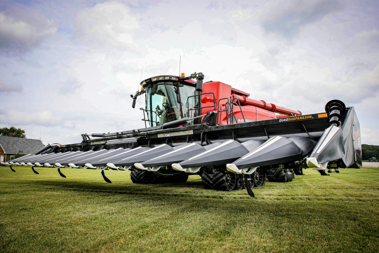 a silver and red tractor parked in the middle of a green field