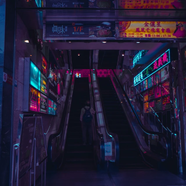 a person walking up a hallway with neon lights