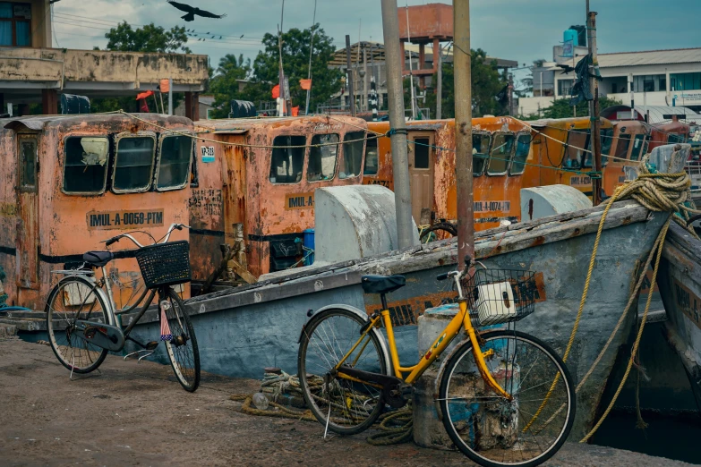 two bicycles leaning against a rusted boat