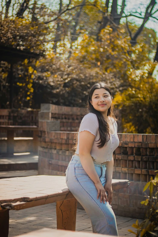 a young woman posing in front of a picnic table