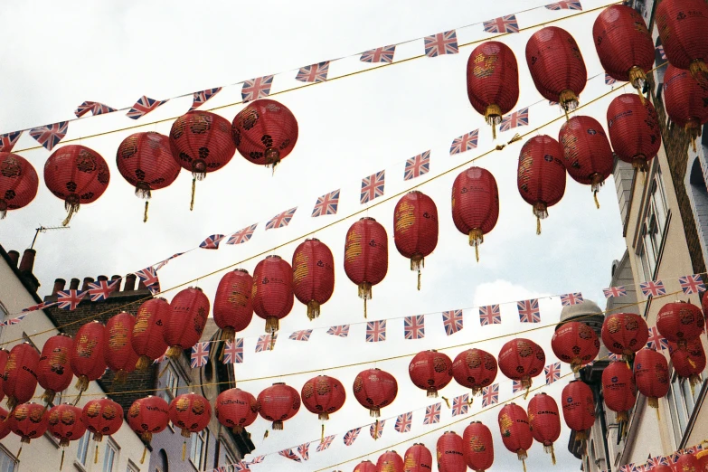 a line of paper lanterns flying over the tops of buildings