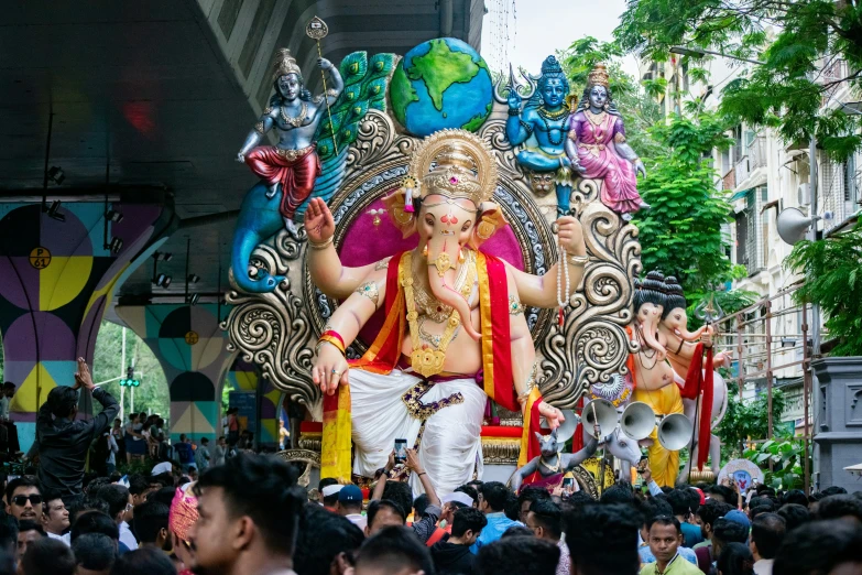 ganesh in float during parade with people on street